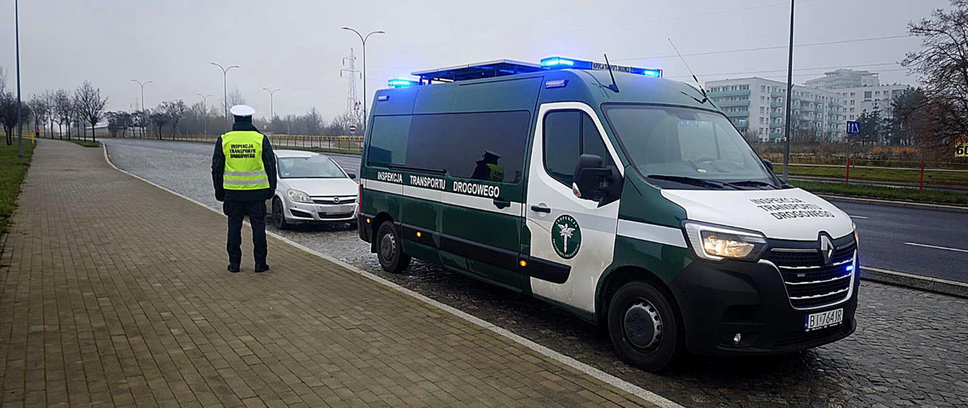 INSPEKTOR PRZY ZATRZYMANYM SAMOCHODZIE