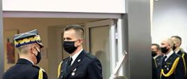 Komendant Główny PSP nadbrygadier Andrzej Bartkowiak w trakcie pasowania na oficera i wręczania aktu nadania pierwszego stopienia oficerskiego funkcjonariuszom PSP. W tle awansowani funkcjonariusze. 