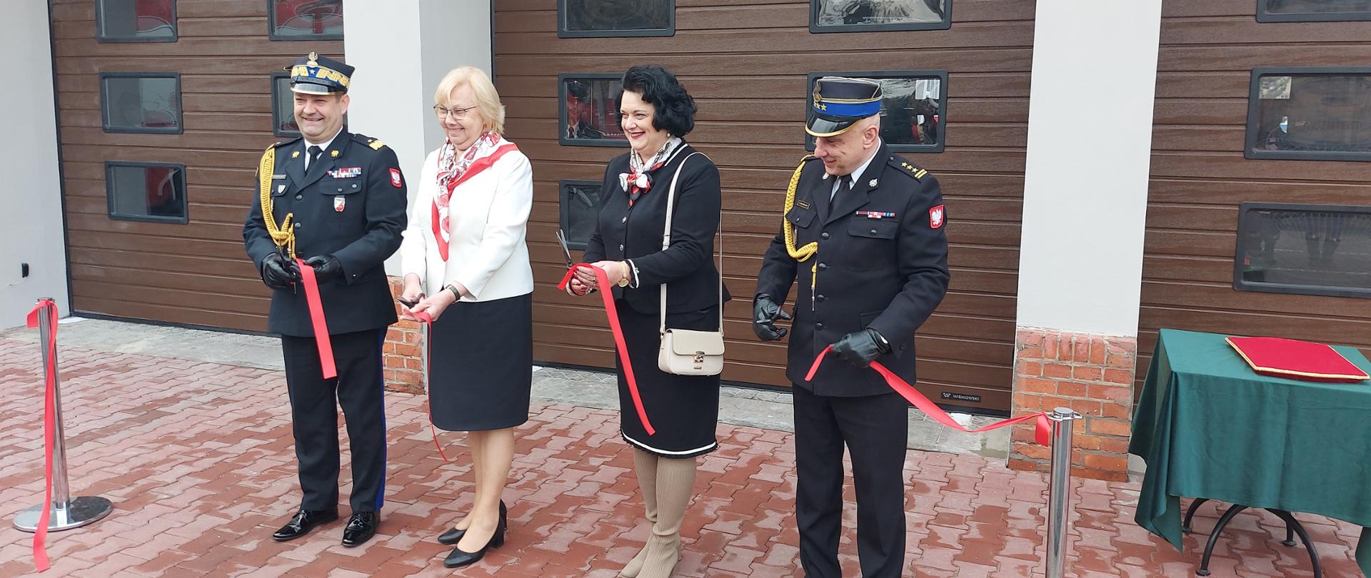 Od lewej Śląski Komendant Wojewódzki Państwowej Straży Pożarnej nadbryg. Jacek Kleszczewski, Prezydent miasta Zabrze Pani Małgorzata Mańka – Szulik, Pani Poseł Barbara Dziuk oraz Komendant Miejski Państwowej Straży Pożarnej w Zabrzu st. bryg. Tomasz Bajerczak przecięli wstęgę przed nowymi bramami garażowymi.