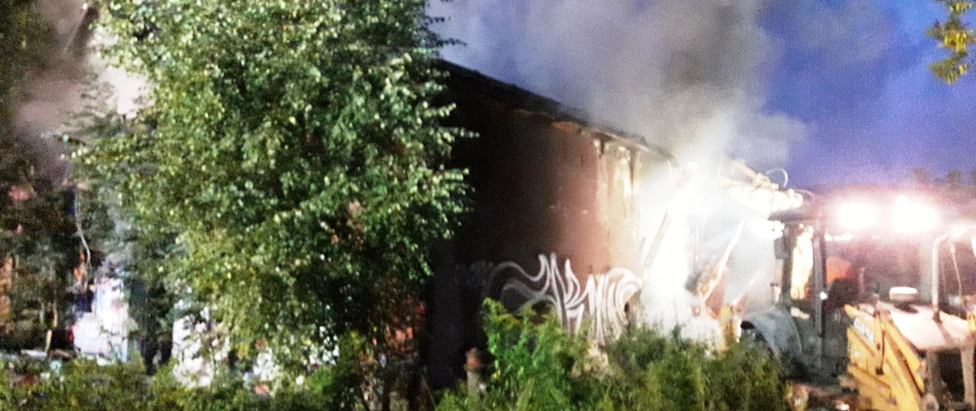 Koparka prowadzi działania przy rozbiórce budynku.