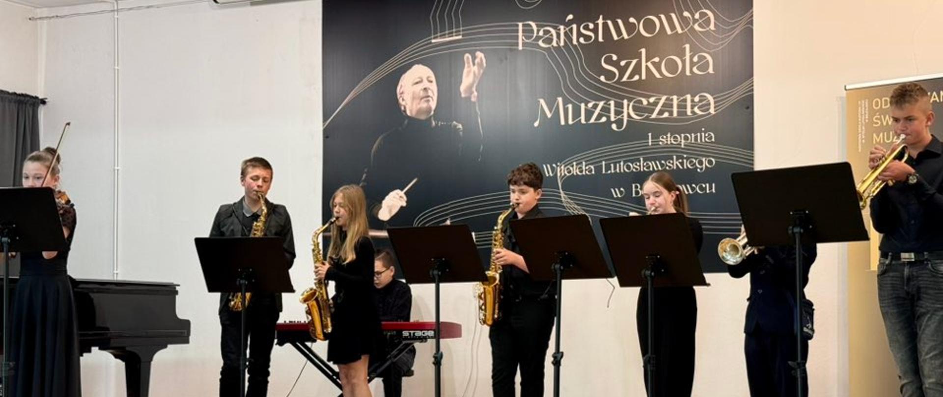 Zdjęcie przedstawiające wykonawców konkursu muzyki rozrywkowej, który odbył się 12 maja 2025 roku w auli szkoły.