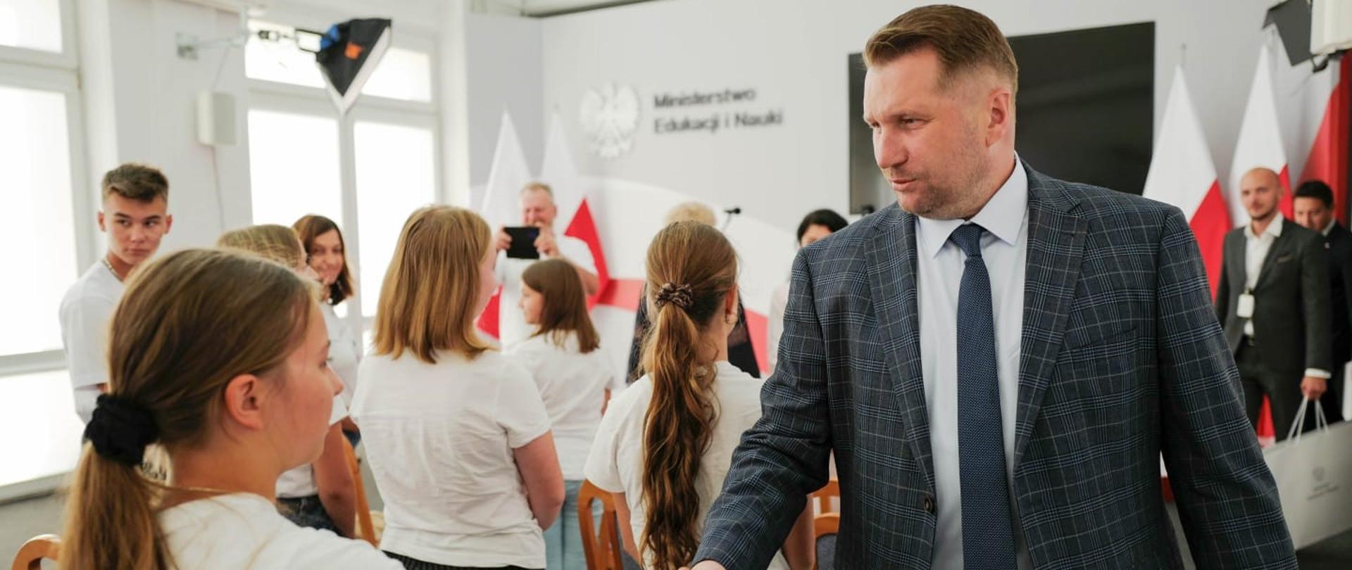 Minister Przemysław Czarnek wita sie z młodzieżą ubraną w koszulki z napisem dumka i mazurek