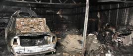 Spalony garaż a w jego wnętrzu po prawej stronie spalony motocykl, po lewej - spalony samochód