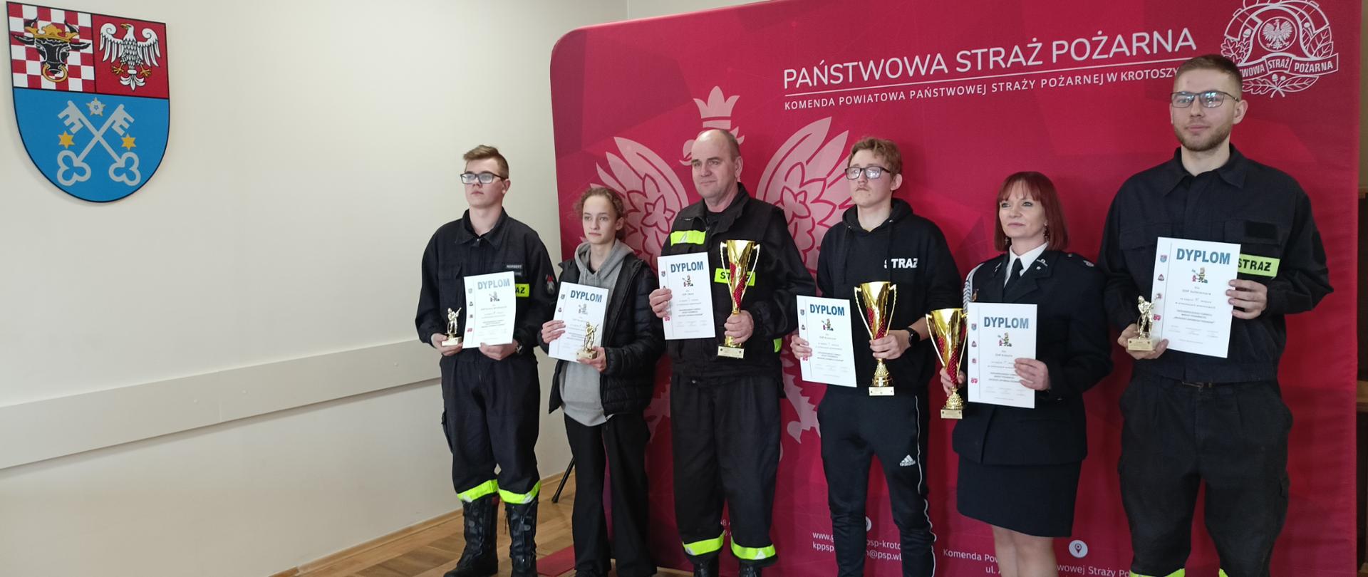 Zdjęcie przedstawia przedstawicieli zarządów miejsko-gminnych ZOSP RP z okolicznościowymi pucharami i statuetkami z zajęcie poszczególnego miejsca w klasyfikacji drużynowej.