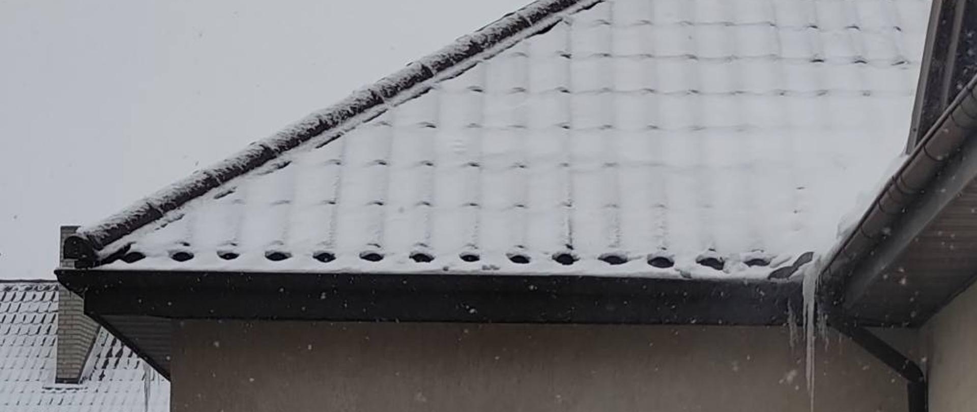 Zdjęcie przedstawia lekko ośnieżony fragment dachu budynku Komendy Powiatowej Państwowej Straży Pożarnej w Zambrowie.