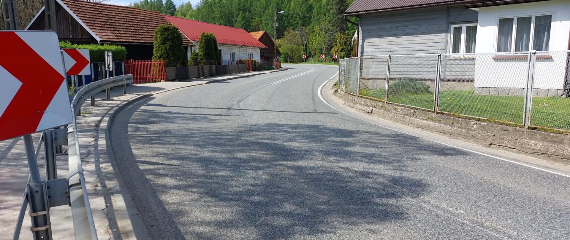 dwa ostre zakręty w centrum miejscowości, w tle las