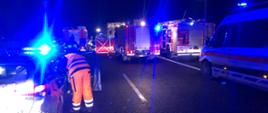 zdjęcie przedstawia miejsce wypadku, widać samochody służb ratowniczych i ratowników podczas działań