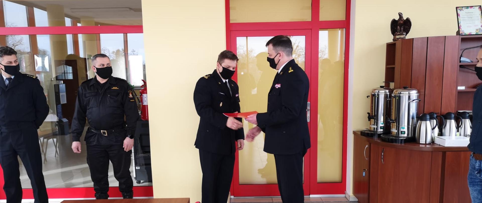 Na zdjęciu widać komendanta żegnającego Dowódcę Jednostki na zapotrzebowanie emerytalne w tle widać zaproszonych gości oraz zastępcę komendanta oraz nowego Dowódcę JRG