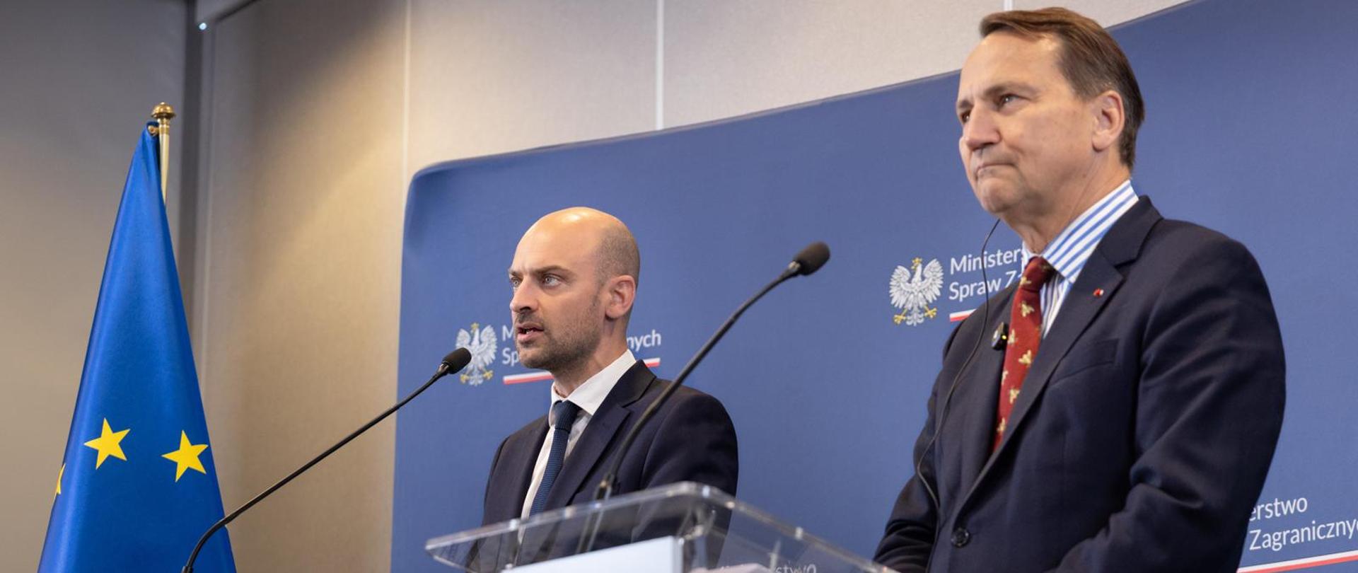 Minister of Foreign Affairs of France and Minister of Foreign Affairs of Poland stand at lecterns during a joint press conference. The lecterns display the flags of France and Poland, with the European Union flag and a Ministry of Foreign Affairs backdrop visible behind them.