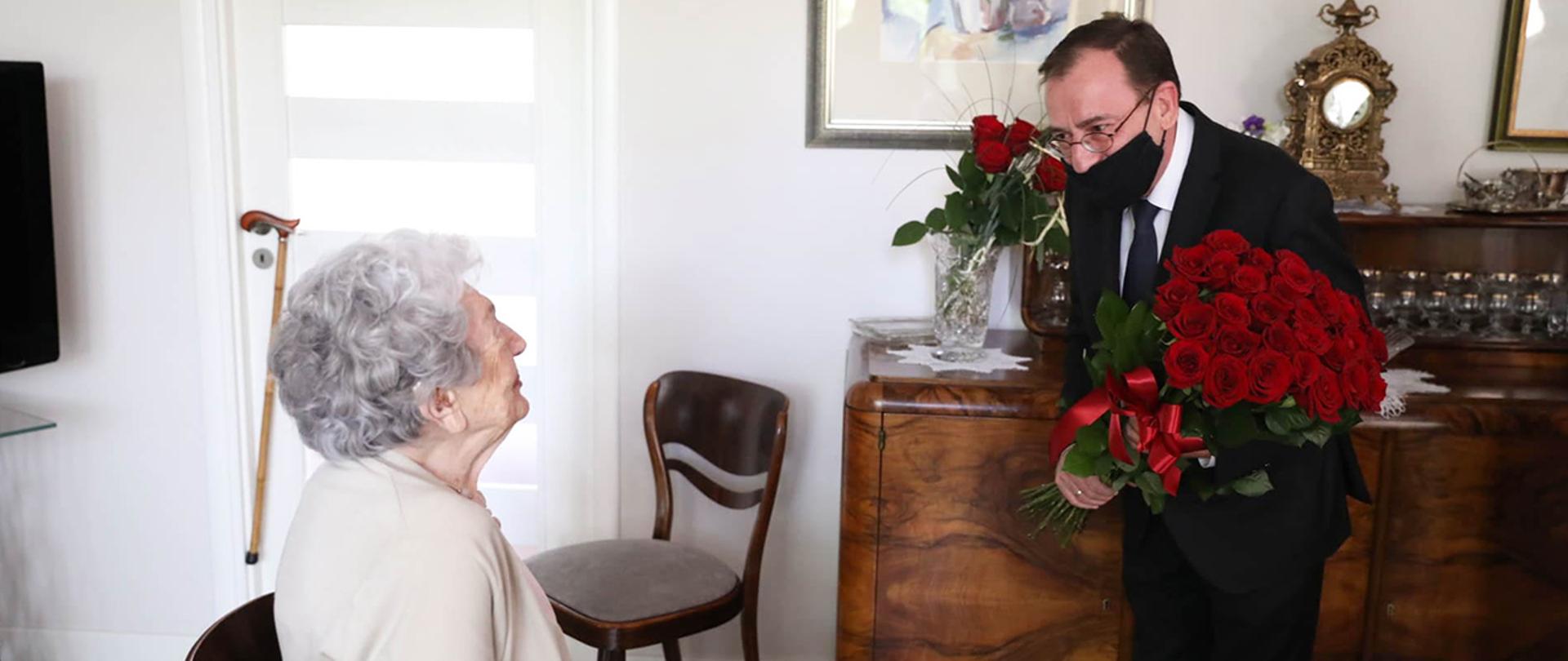 Pani Maria Czernek małżonki Jana Borkowskiego, funkcjonariusza Policji Państwowej zamordowanego przez NKWD w kwietniu 1940 r. wita się z Mariuszem Kamińskim ministrem SWiA i Jarosławem Szymczykiem komendantem głównym policji.