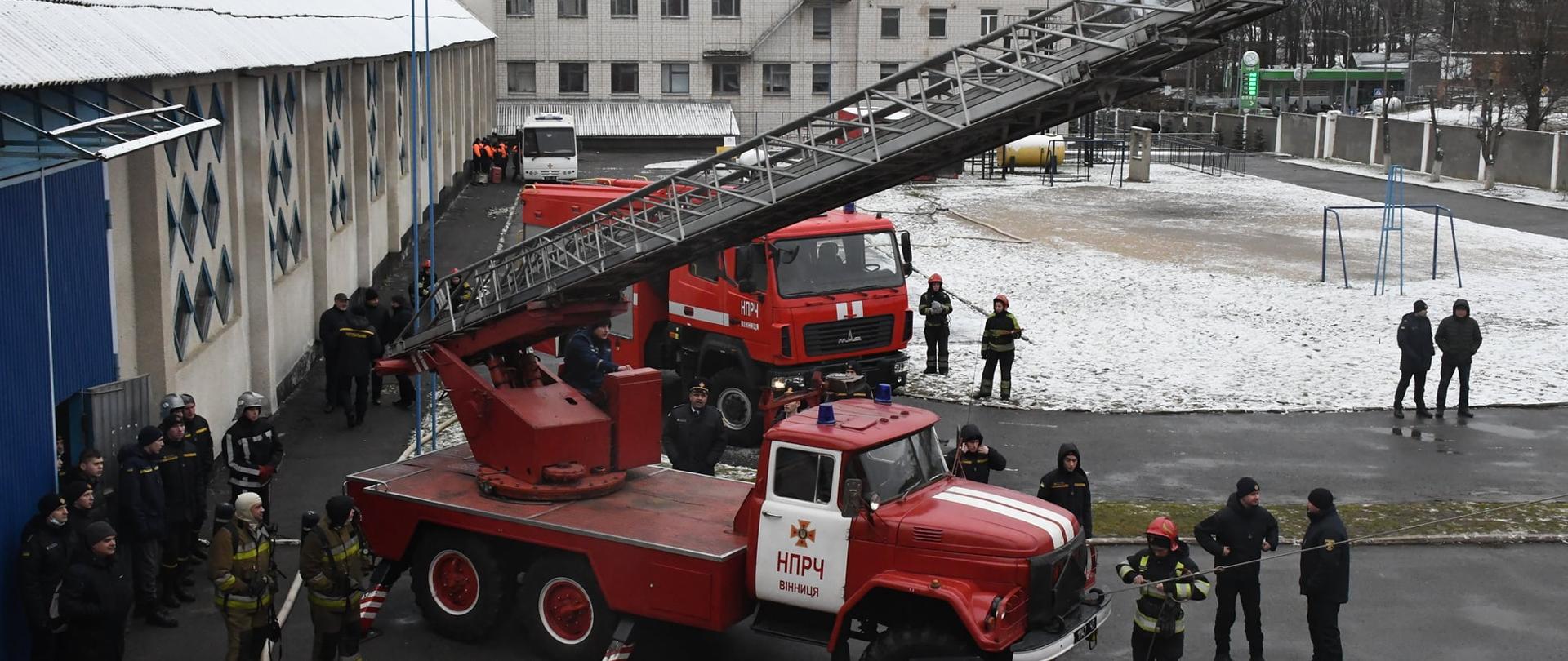 Wóz strażacki i grupa ludzi