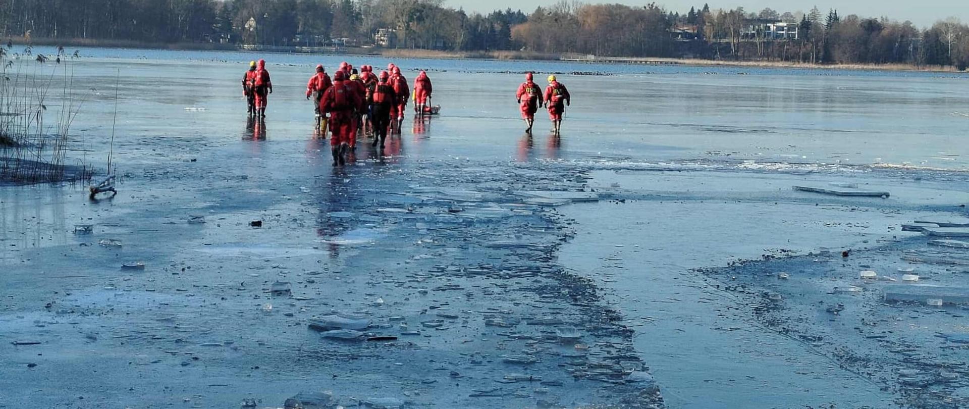 Grupa ćwiczących strażaków na lodzie