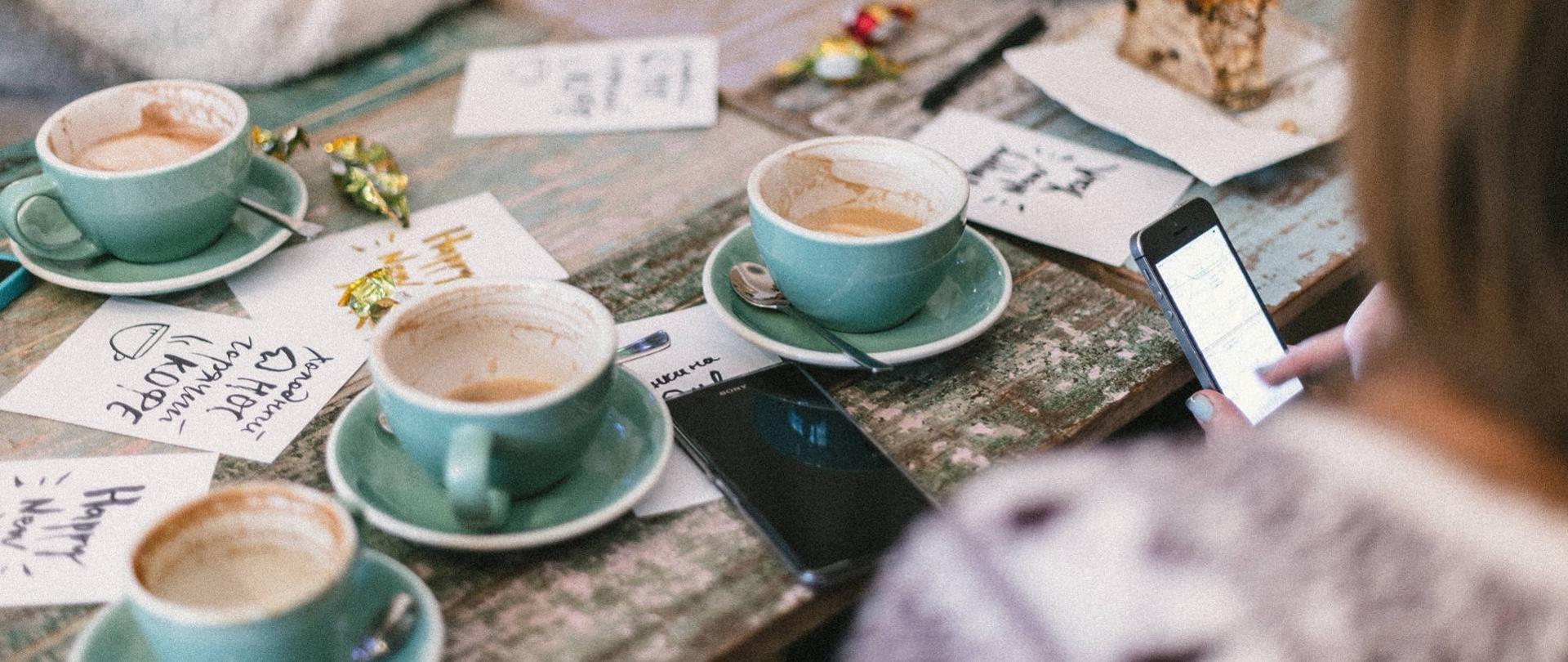 Widok na stół z kawami, telefonem i notatkami