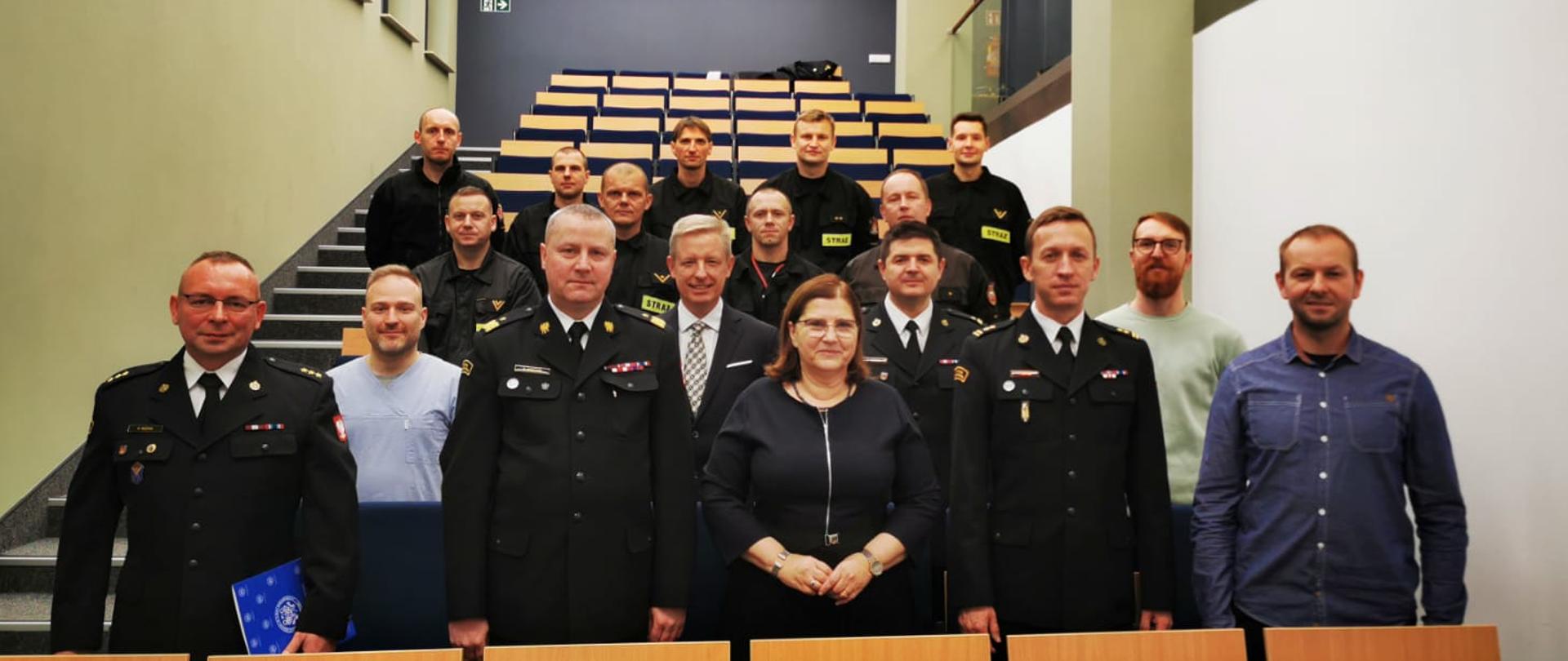 Zdjęcie grupowe na którym są zaproszeni goście, kadra dydaktyczna Uniwersytetu Medycznego w Poznaniu oraz grupa strażaków biorących udział w kursie.