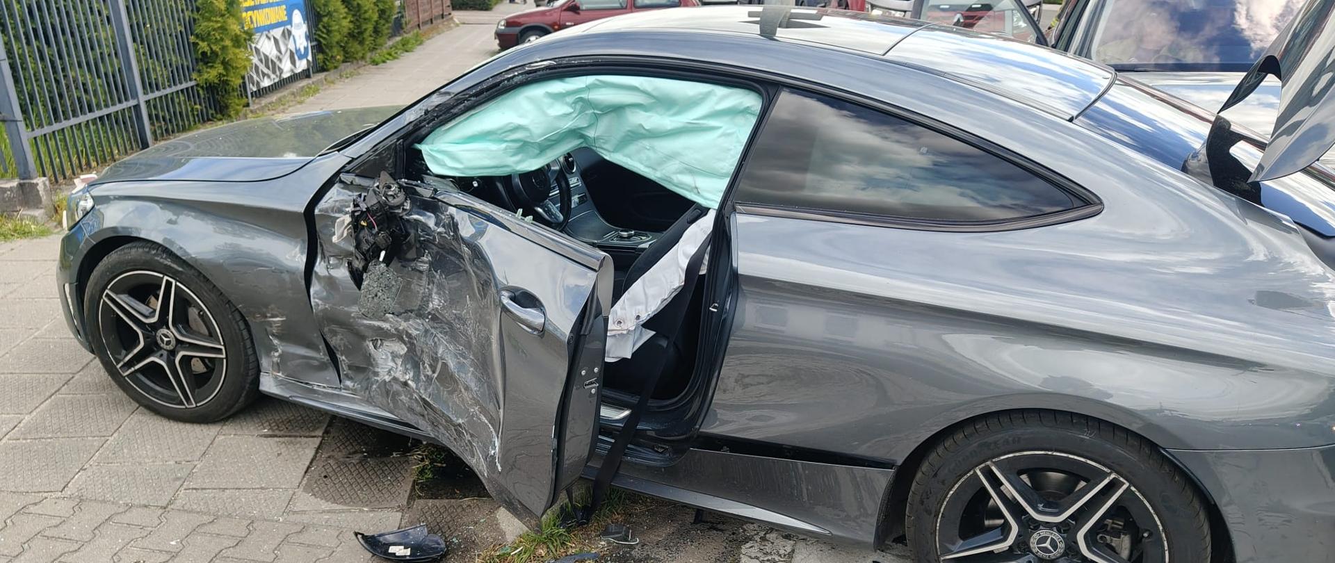 Uszkodzony lewy bok samochodu, jest na poboczu