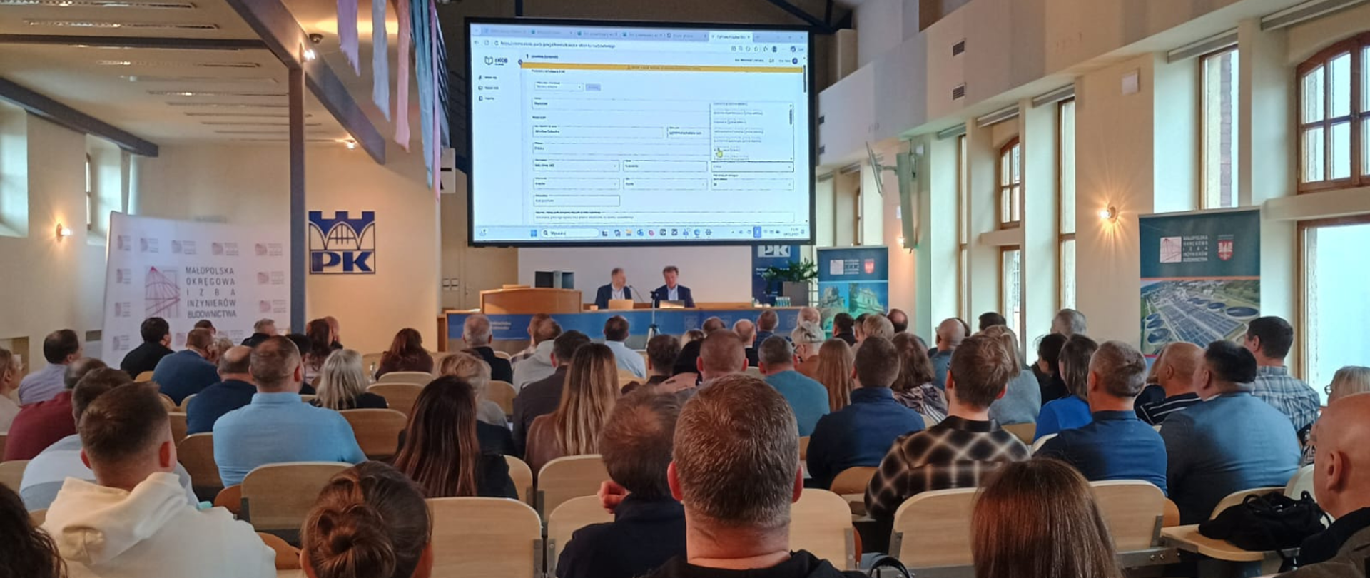 Na zdjęciu uczestnicy szkolenia w sali szkoleniowej w tle prowadzący szkolenie.