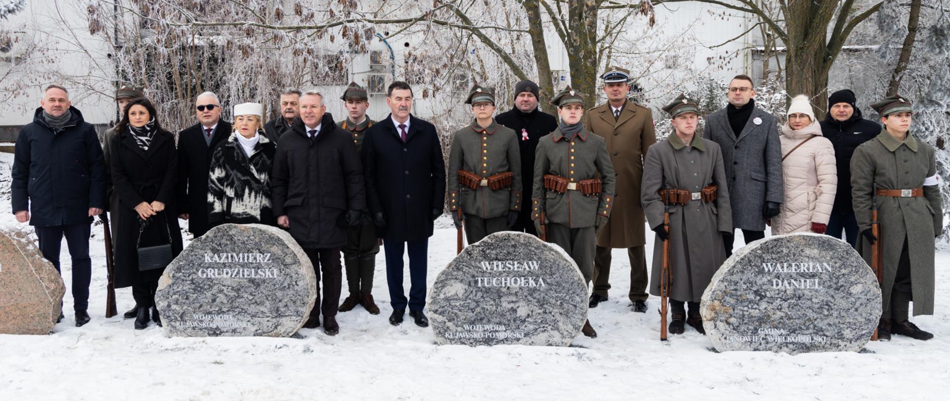 Wicewojewoda Kujawsko-Pomorski Piotr Hemmerling oraz pozostali goście stoją za pomnikami Powstańców Wielkopolskich