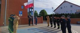 Strażacy wokół masztu gdzie wciągana jest flaga na maszt