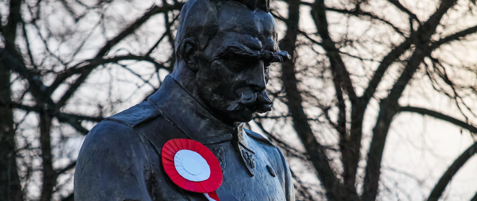 Pomnik marszałka Józefa Piłsudskiego z kotylionem w barwach narodowych