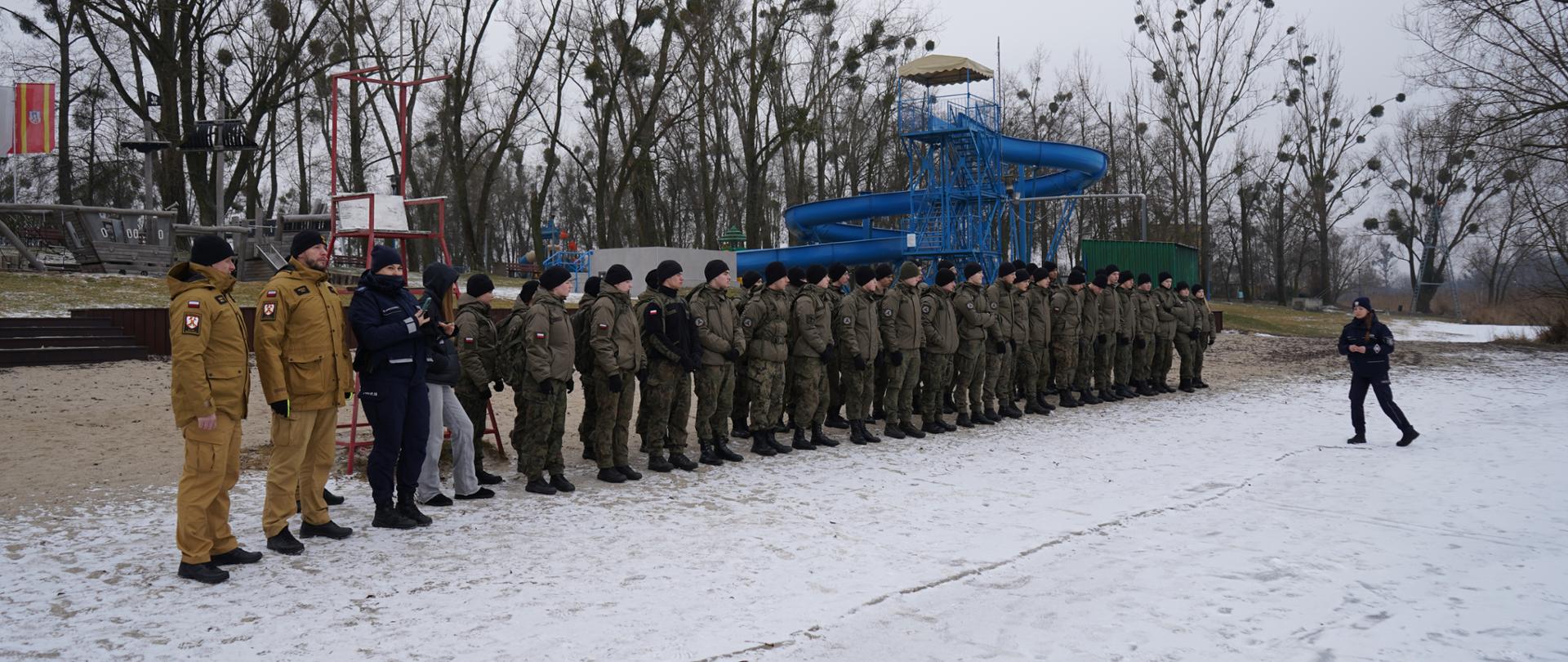 Funkcjonariusze Państwowej Straży Pożarnej w Środzie Wlkp. oraz Policji podczas odprawy z uczniami Zespołu Szkół Akademickich w Środzie Wlkp. nad zalewem średzkim.