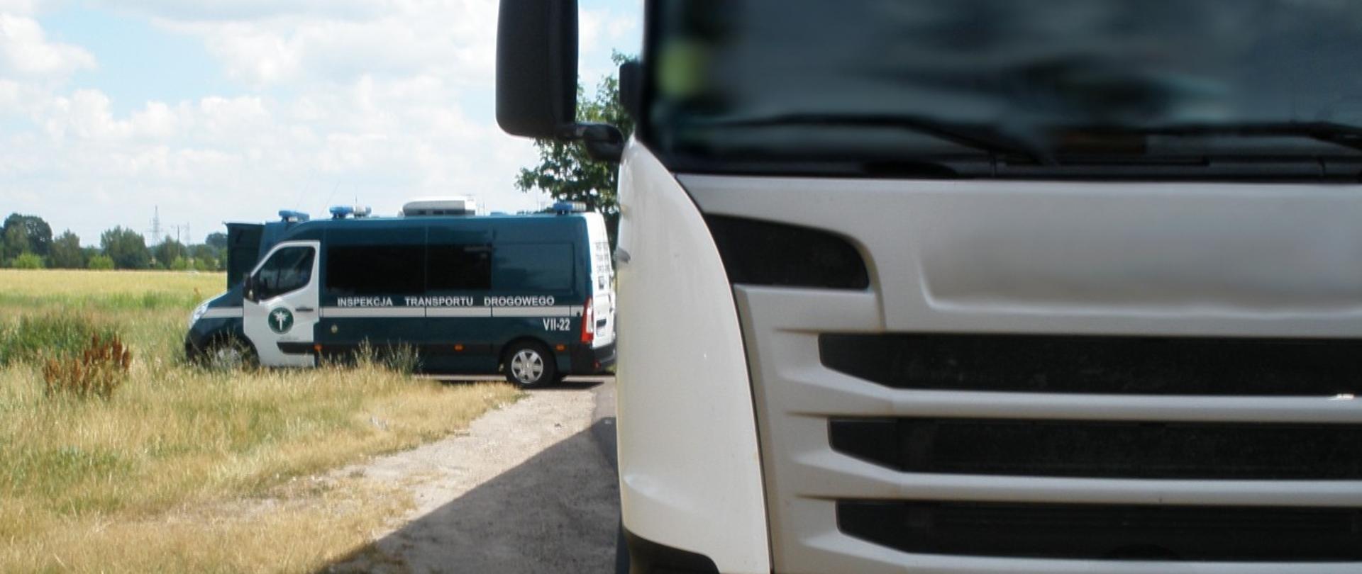 Na pierwszym planie (od prawej strony) przód ciężarówki. W tle oznakowany radiowóz mazowieckiej ITD typu furgon.