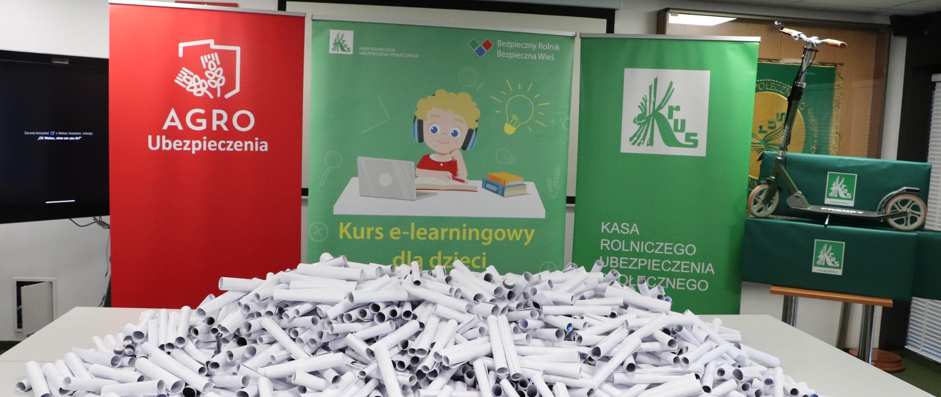 na pierwszym planie plakaty, na drugim zgłoszenia