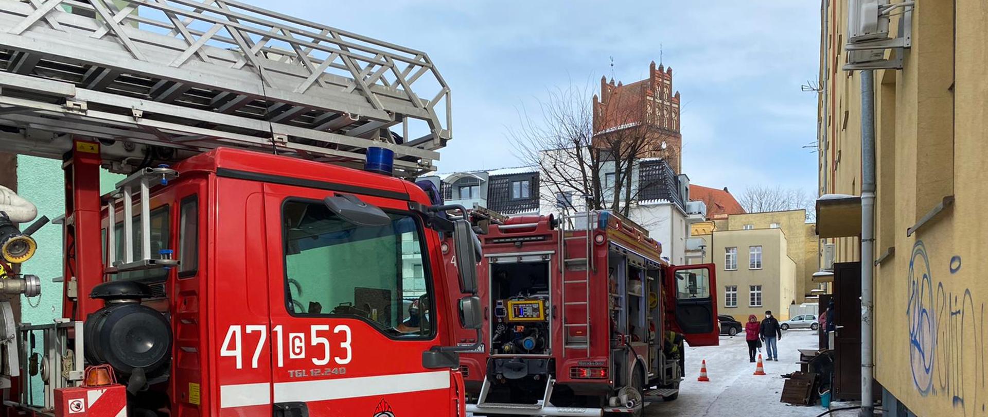 Przybyłe na miejsce zdarzenia zastępy straży pożarnej prowadzą działania w budynku mieszkalnym wielorodzinnym w Lęborku