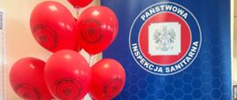 Baner Państwowej Inspekcji Sanitarnej oraz czerwone balony