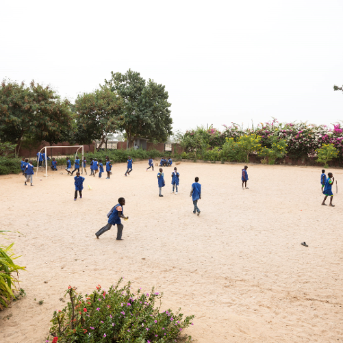 Dzieci grające w piłkę nożną na boisku szkolnym