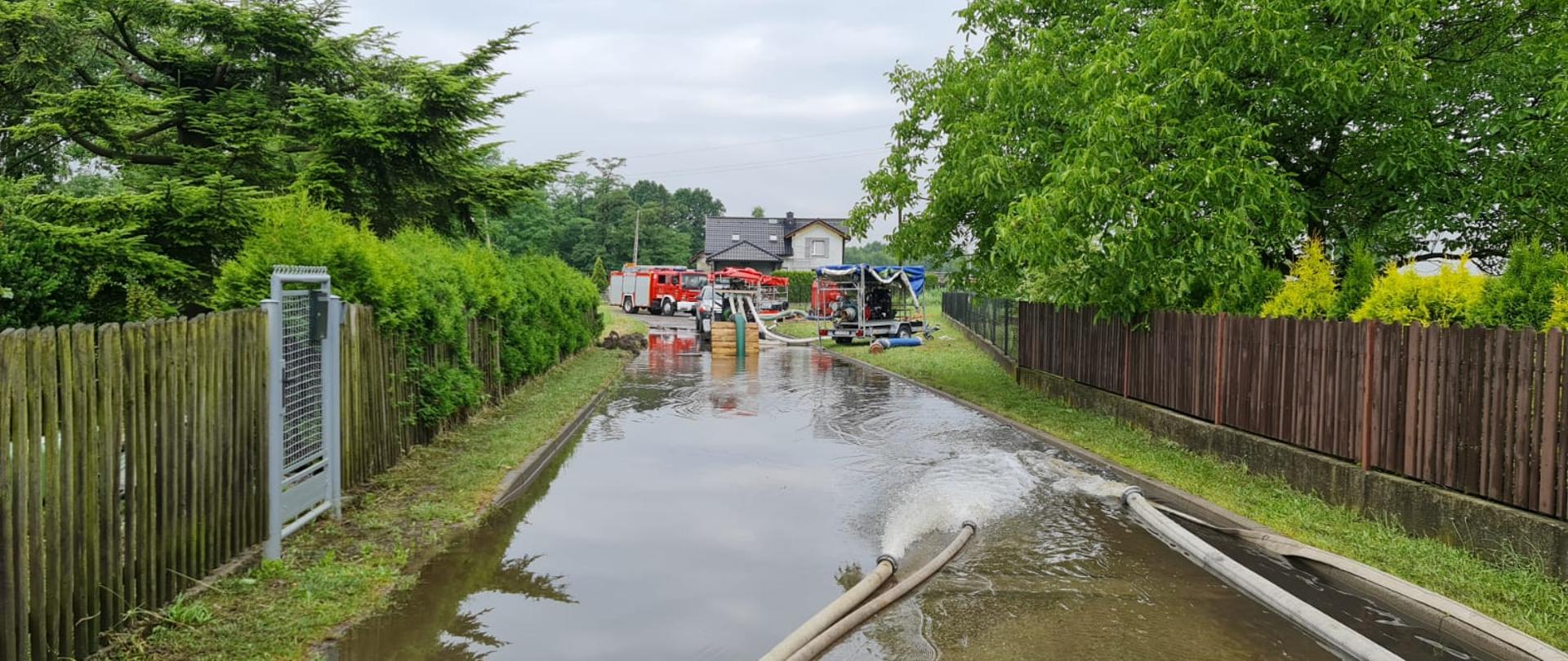 Zalana ulica, w tle sprzęt strażacki