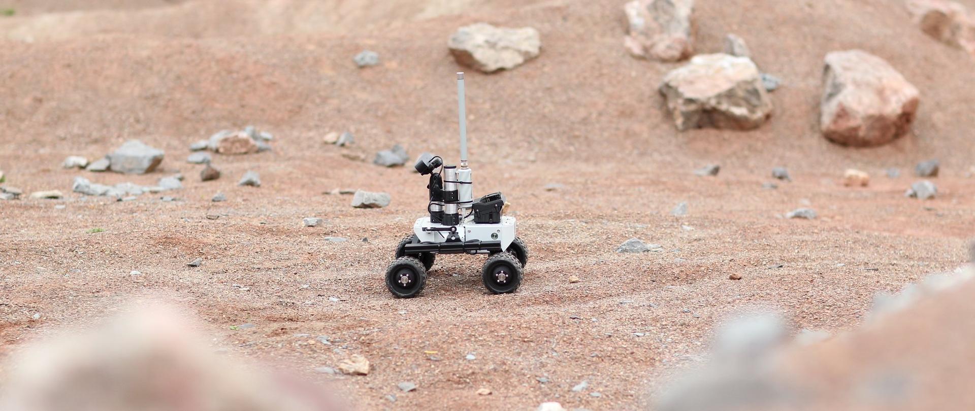 Robot jedzie po pustynnym torze.
