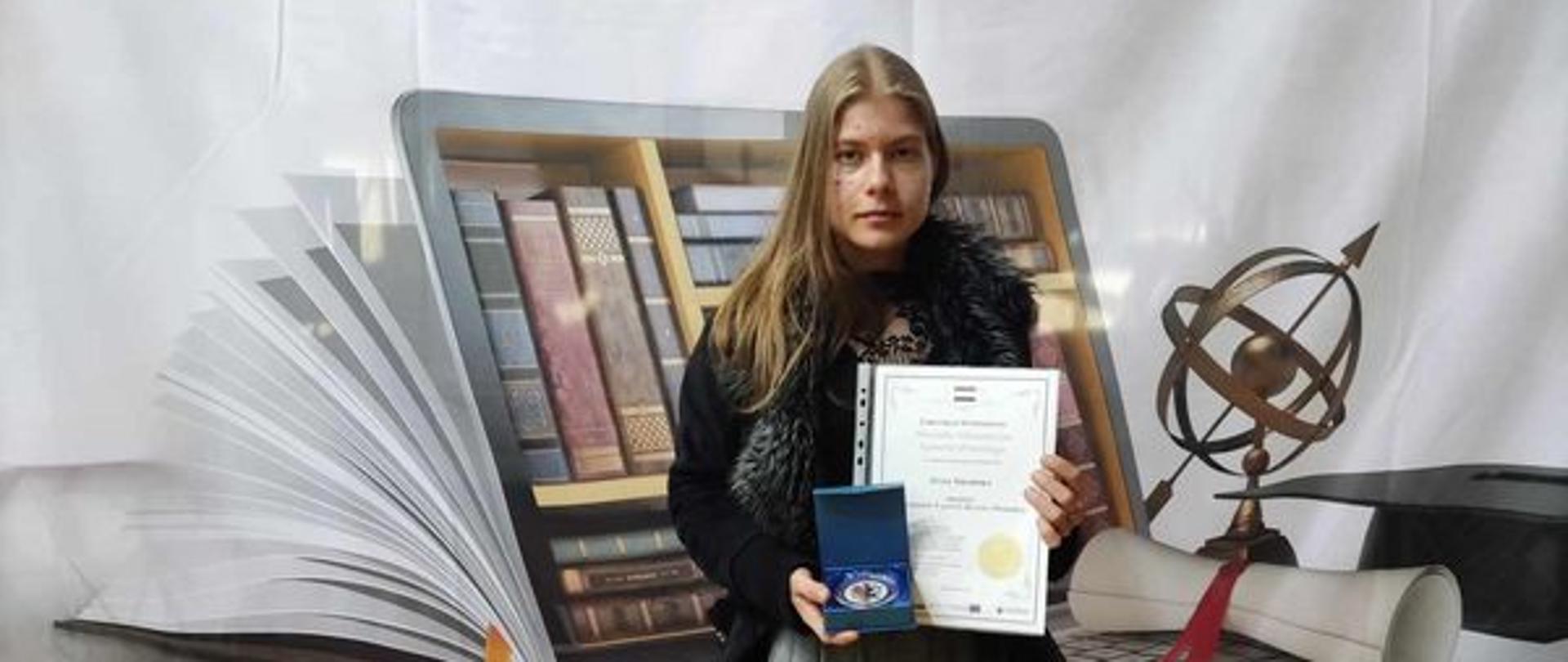 Uczennica trzymająca w rękach dyplom