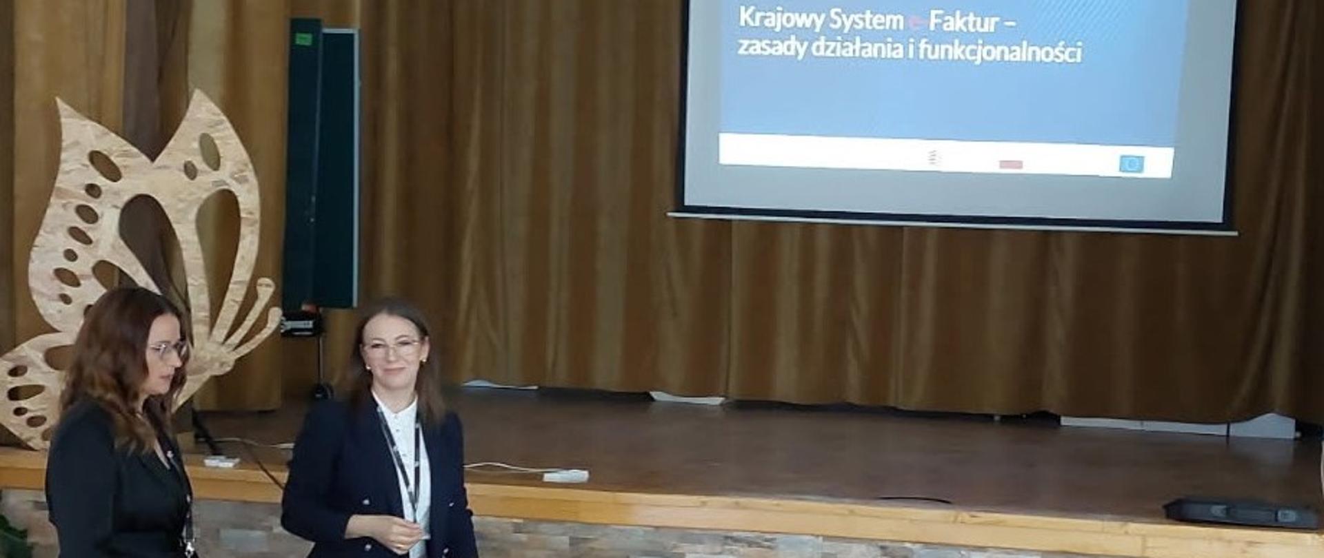 Ekspertki stoją przed ekranem na którym wyświetlana jest prezentacja.