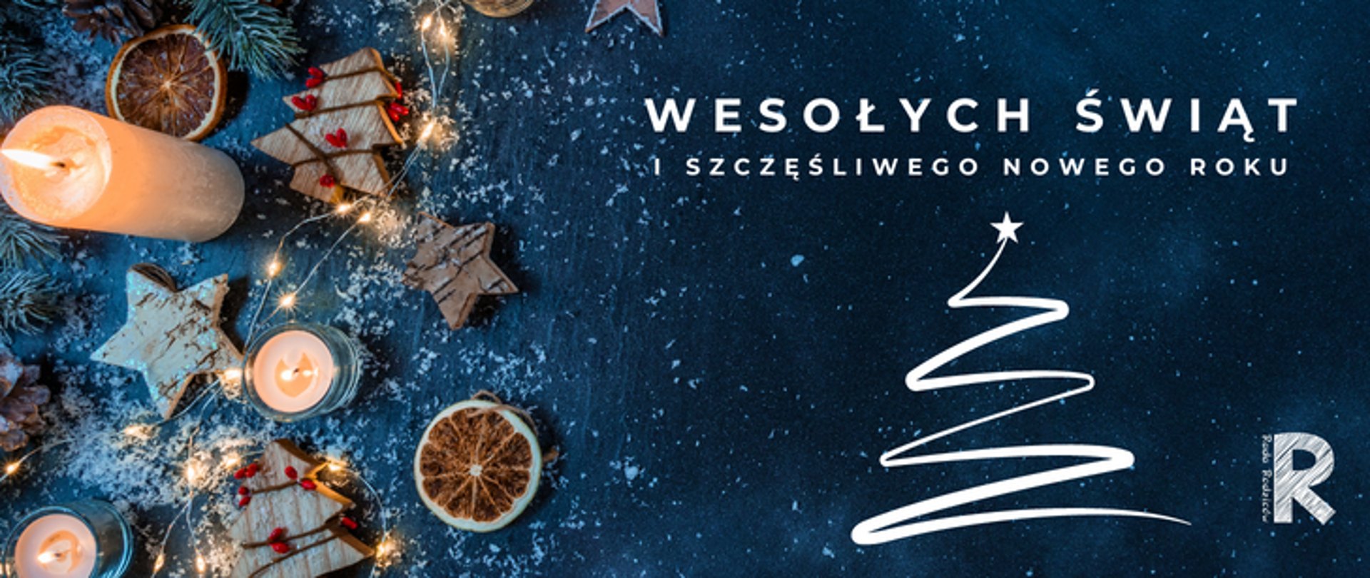 zdjęcie przedstawia kartkę świąteczną na granatowym tle, po lewej stronie ozdoby świąteczne, na górze napis wesołych świąt i szczęśliwego nowego roku, pod spodem grafika biała choinki, po prawej logo symfonii 