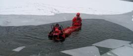 Na zdjęciu strażacy ćwiczą na zalodzonym zbiorniku wodnym