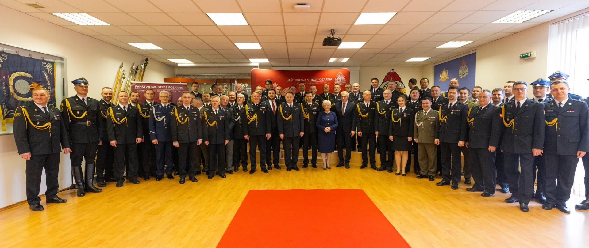 Pamiątkowe zdjęcie uczestników uroczystej zbiórki w siedzibie Komendy Wojewódzkiej Państwowej Straży Pożarnej. 