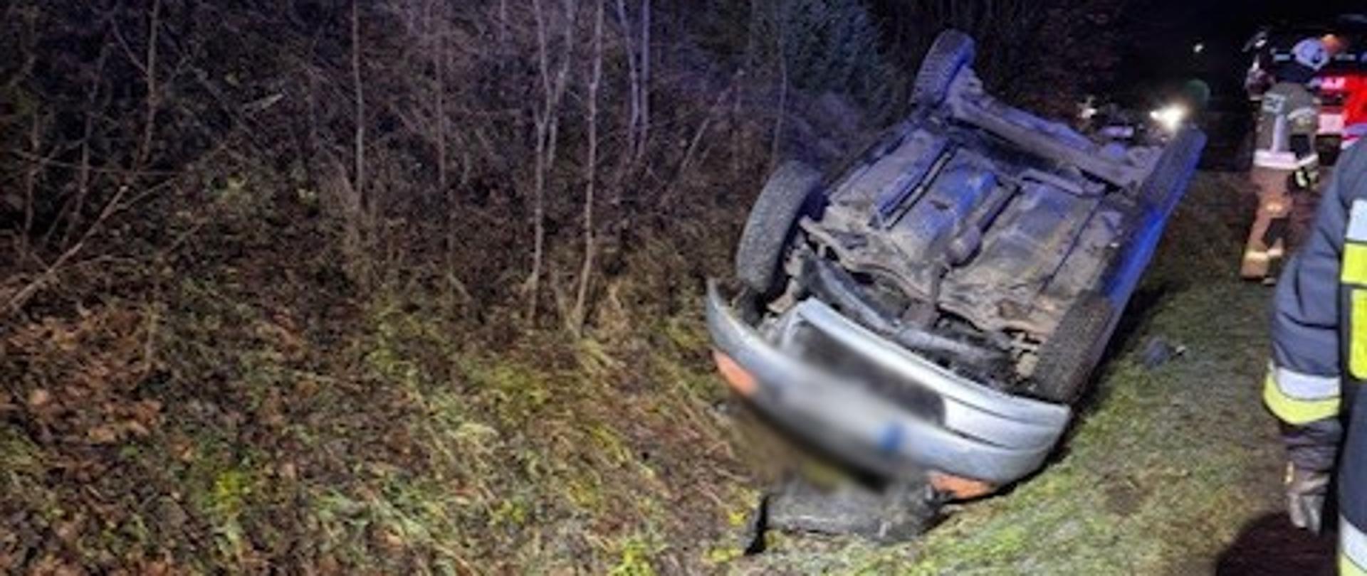 Samochód osobowy na dachu w przydrożnym rowie