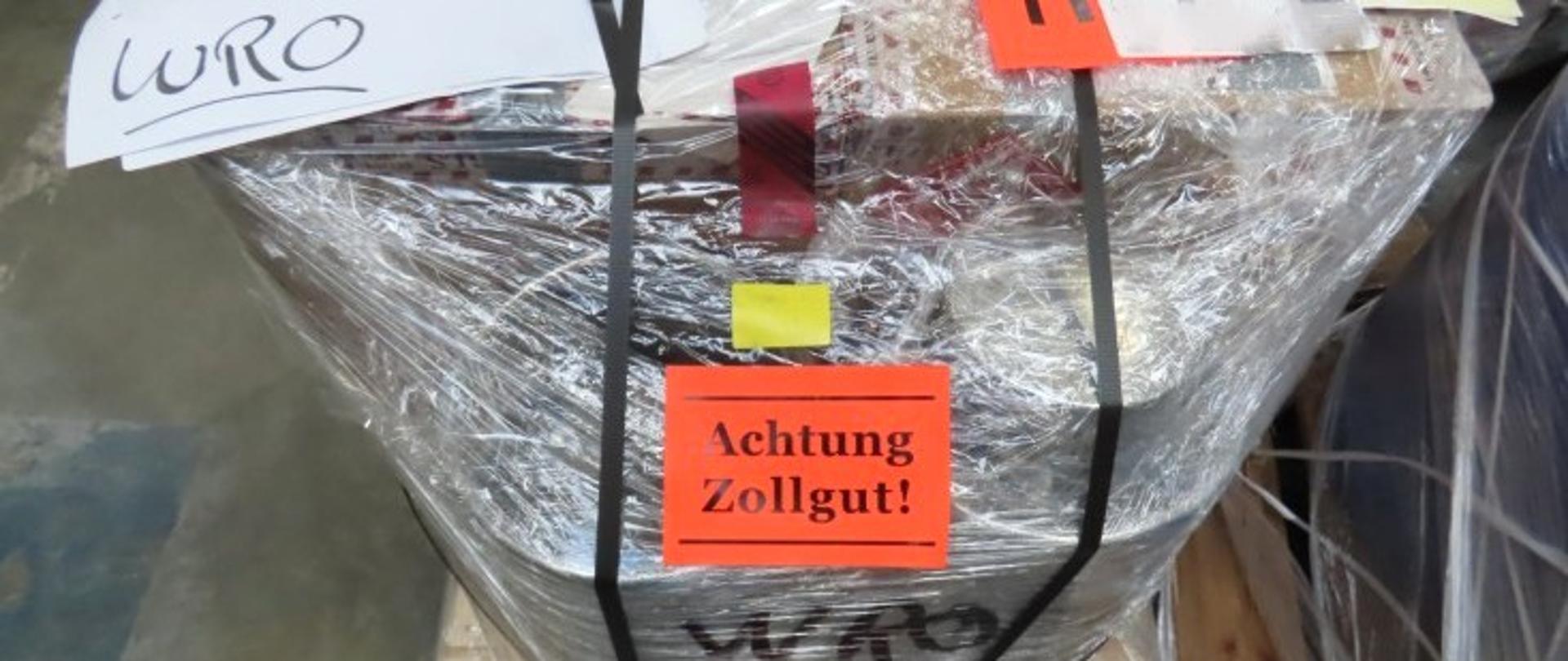 Na palecie zafoliowany pakunek z pomarańczową naklejką i napisem Achtung Zollgut! (źródło: WIOŚ)