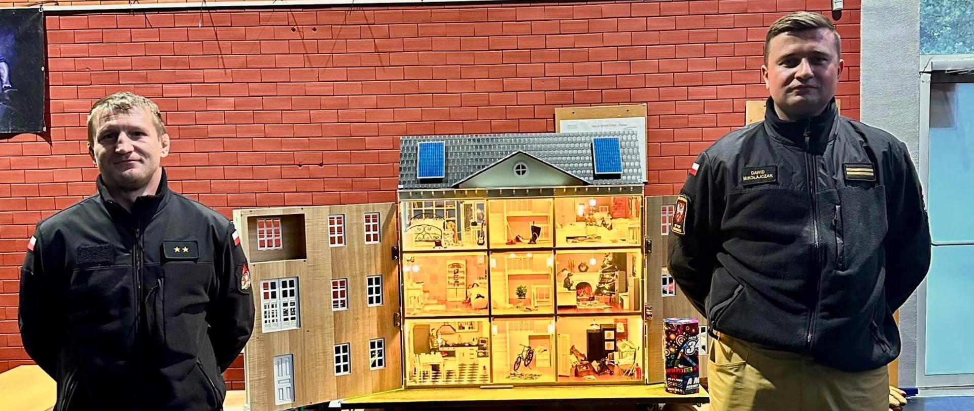 Strażacy prowadzą działania edukacyjne podczas finału WOŚP, prezentując makietę budynku i zasady bezpieczeństwa.