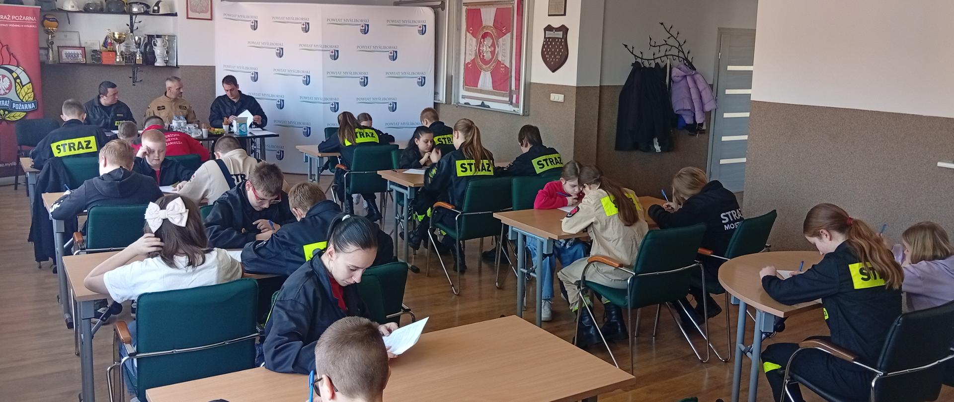 Zdjęcie przedstawia uczestników OGÓLNOPOLSKIEGO KONKURSU WIEDZY POŻARNICZEJ PT. "młodzież zapobiega pożarom" stojących z dyplomami i nagrodami.