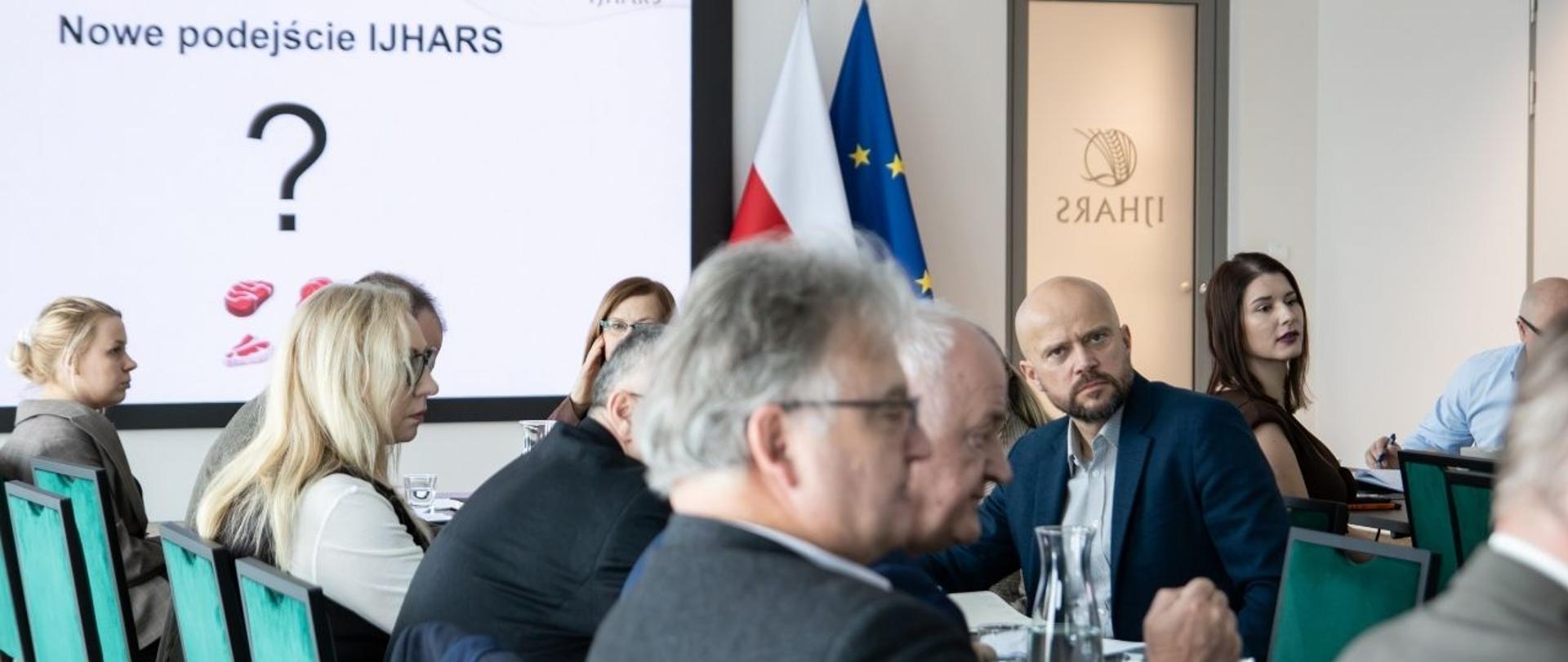 Uczestnicy spotkania branżowego podczas prezentacji w sali konferencyjnej IJHARS; w tle slajd z napisem »Nowe podejście IJHARS?« oraz flagi Polski i Unii Europejskiej.