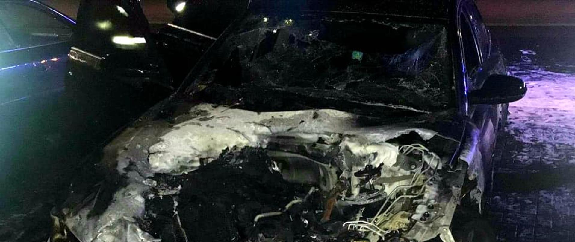 Zdjęcie przestawia wnętrze spalonego auta - audi A6, cała komora silnika uległa spaleniu.
