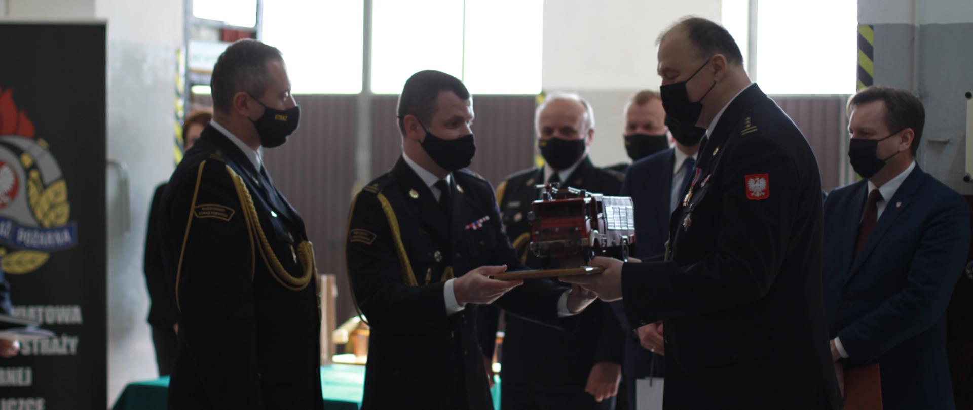 Małopolski Komendant Wojewódzki PSP wraz z Komendantem Powiatowym PSP w Wieliczce wręczają pamiątkowy upominek odchodzącemu na zaopatrzenie emerytalne st. bryg. Markowi Rodakowi