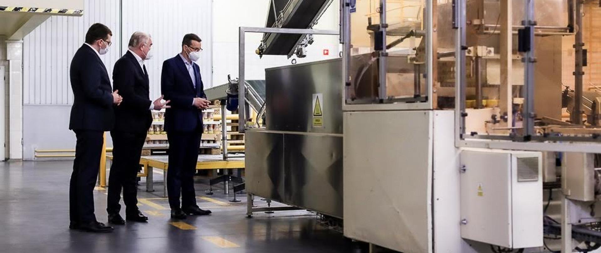 Premier Mateusz Morawiecki i zarząd firmy ogląda maszynę.