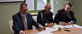 na zdjęciu widać przedstawiciela jednostki OSP, Komendanta PSP oraz Burmistrza miasta i gminy podczas podpisywania porozumienia