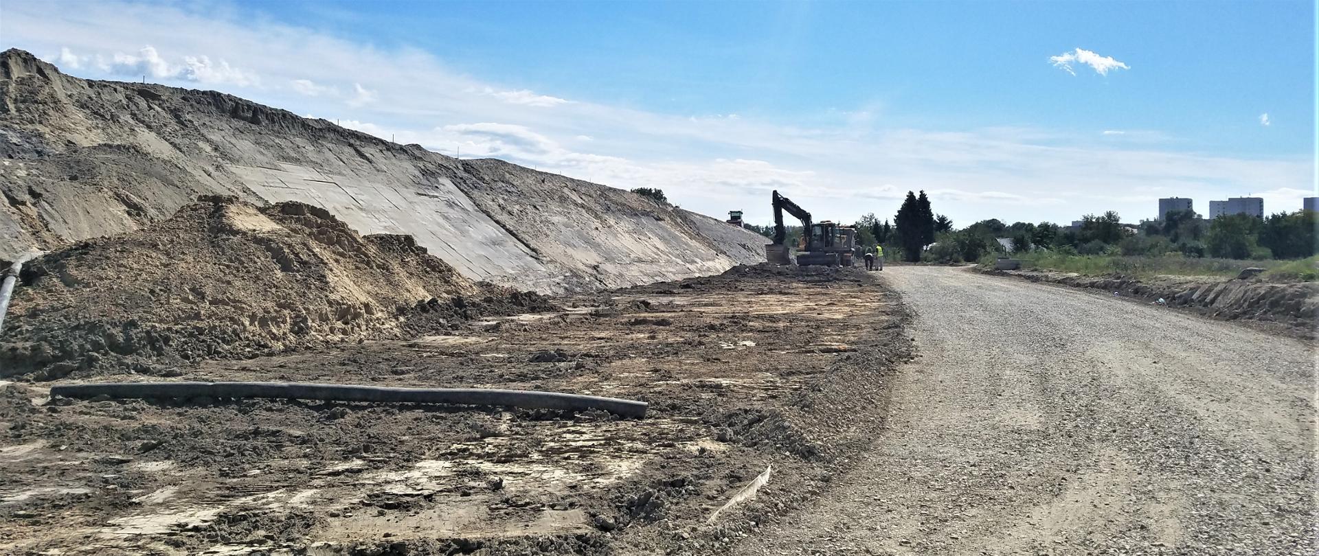 na zdjęciu nasyp ziemny obok którego stoi koparka i drogowcy