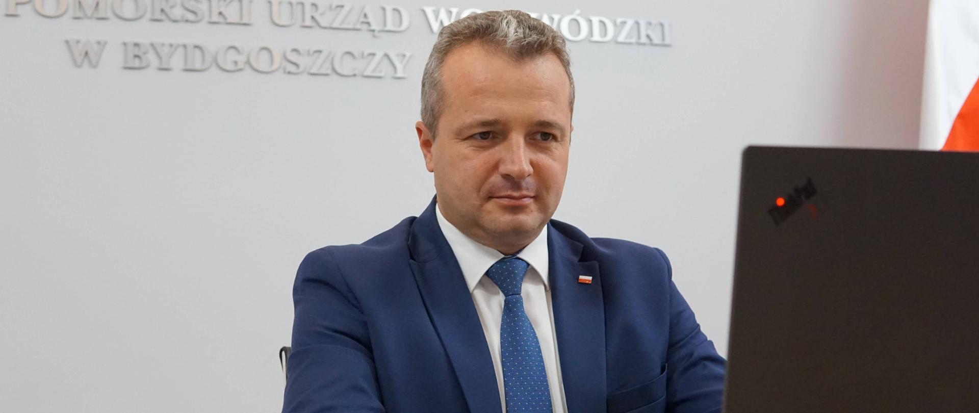 Wojewoda Mikołaj Bogdanowicz podczas telekonferencji przy laptopie