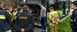 Strażacy słuchają i oglądają wnętrze jednostki zasilającej nowy autobus elektryczny