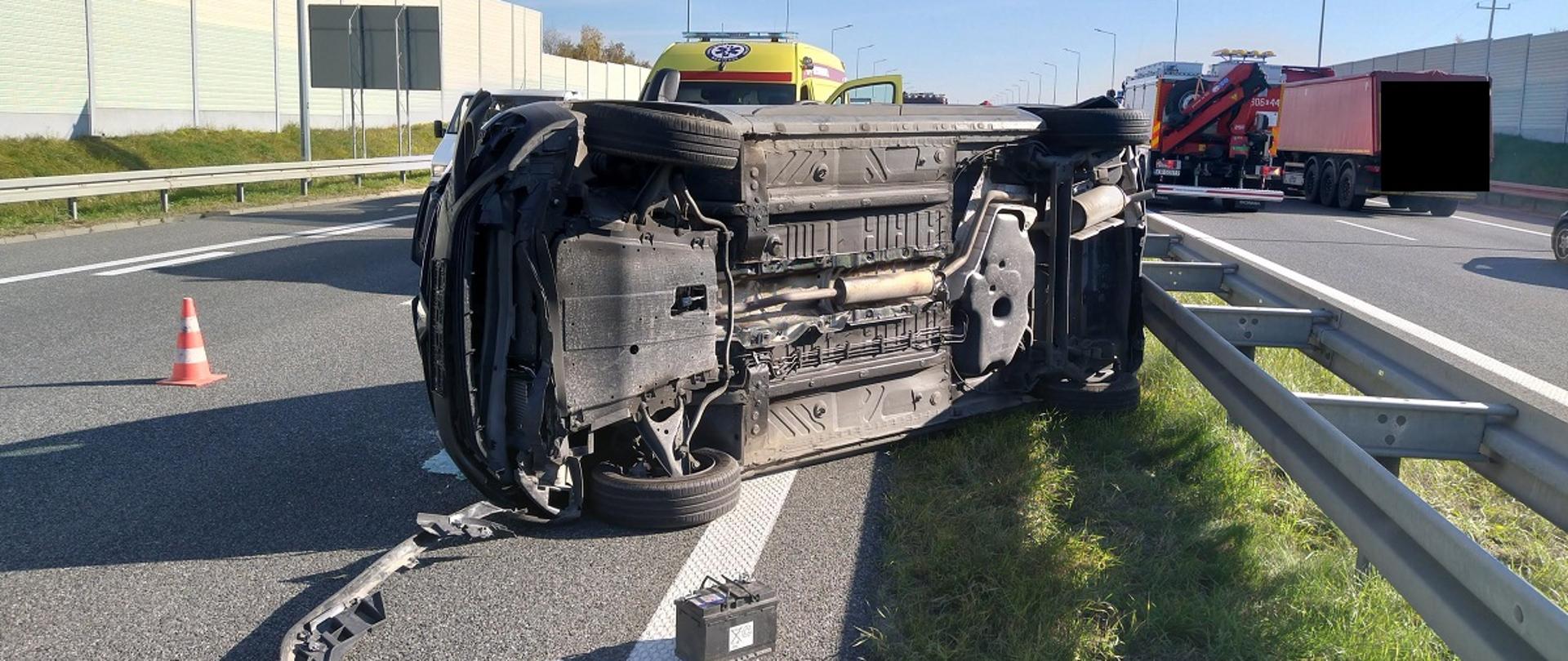 Zdjęcie przedstawia leżący samochód na boku