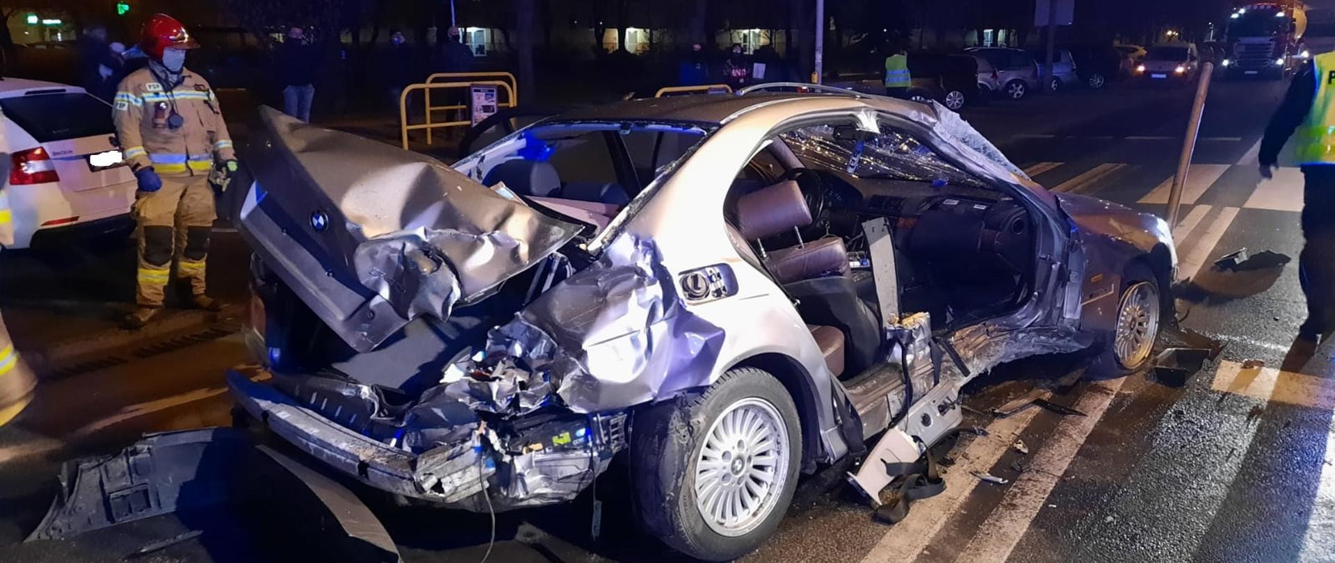 Na zdjęciu rozbity samochód osobowym z lewej strony stoi ratownik PSP